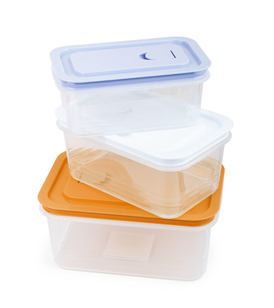 Plastic containers for food on wooden table on blue background